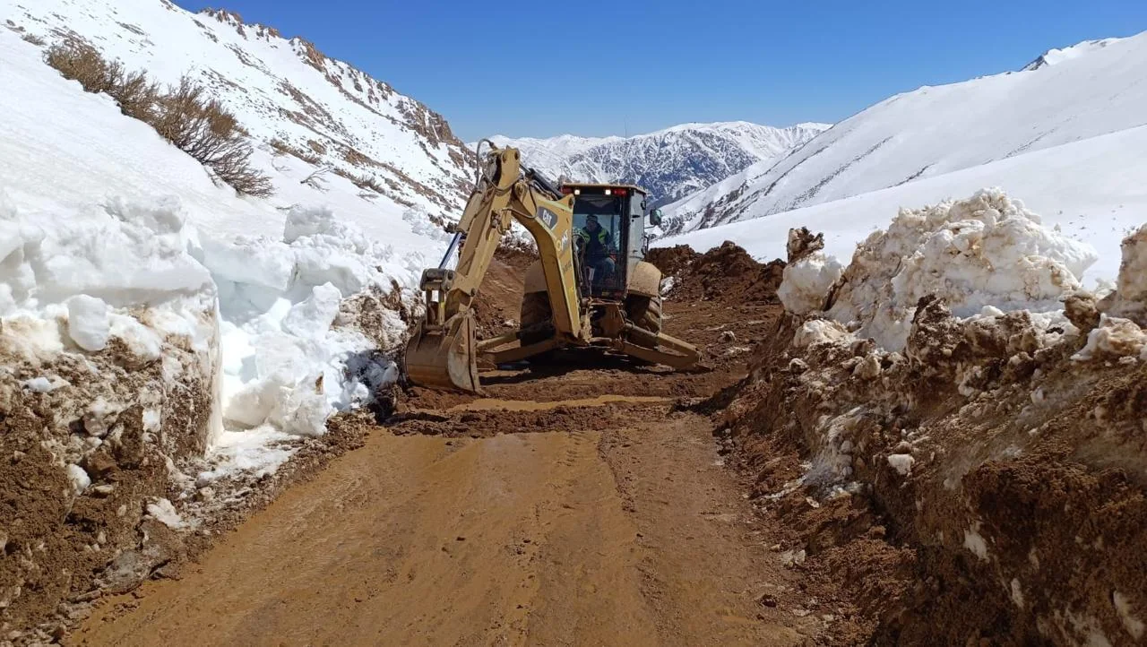 Retroexcavadora QMT habilitando un camino rodeado de nieve
